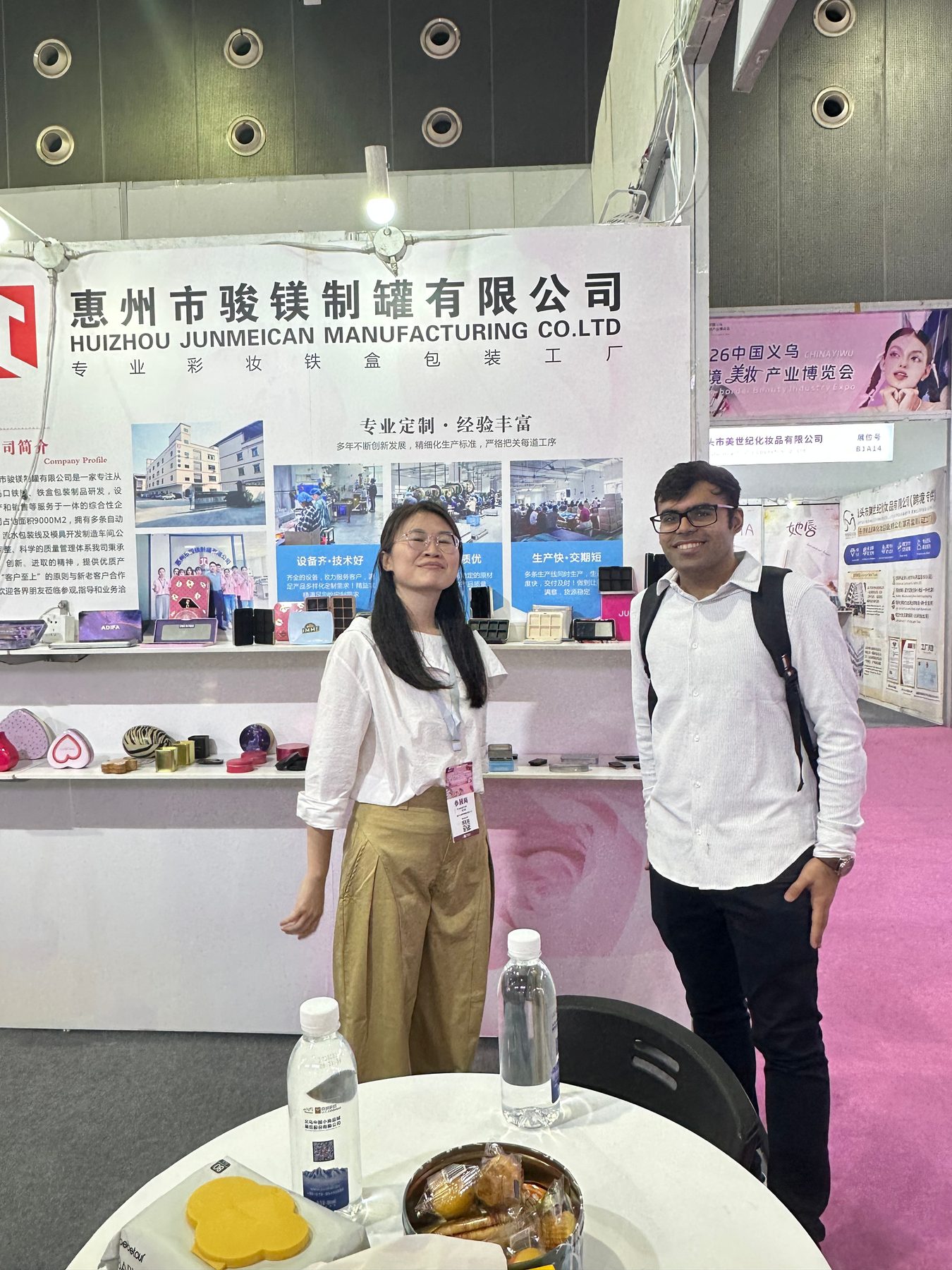Junmei representative discussing tin packaging with an overseas buyer at an exhibition