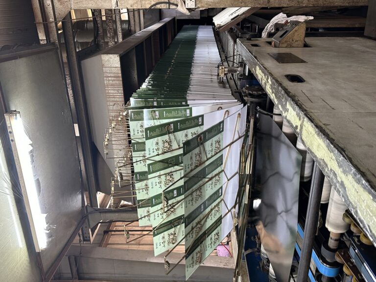 Printed tinplate sheets entering the oven-drying stage at Junmei