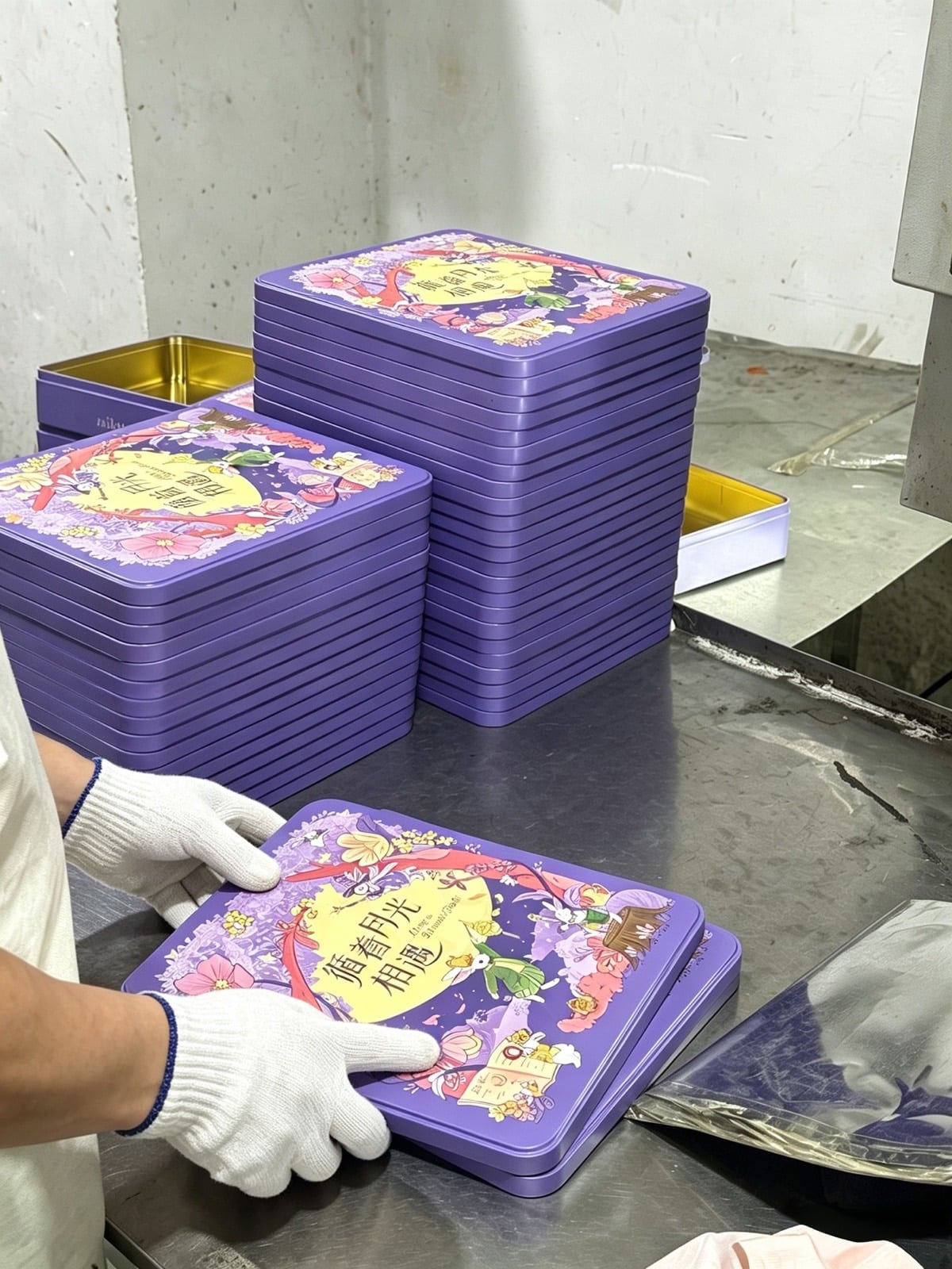 Stacks of finished purple printed tins inside Junmei production