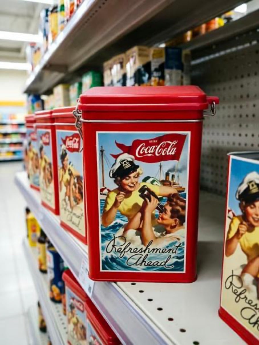 Coca-Cola tins from a confirmed collaboration shown in retail display